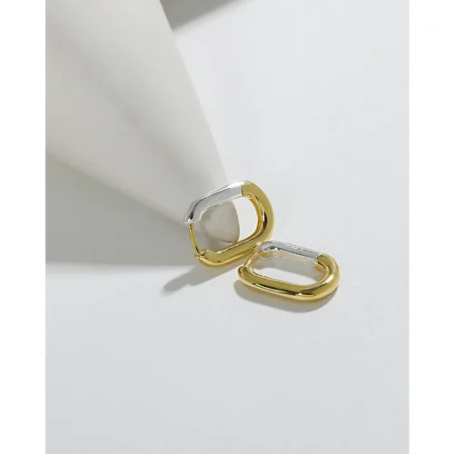 Pair of INS style smooth two-tone S925 sterling silver and 18K gold-plated U-shaped hoop earrings on white sculptural cone