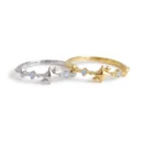 Silver and gold celestial starburst rings with small blue stones resting on a white background.