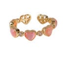 Front view of the 14K gold-plated adjustable ring with pink heart-shaped glass cat's eye stones on a white background.